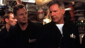 ‘K-19: The Widowmaker’ 4K UHD Blu-Ray Review – Kathryn Bigelow Brings Tension-Filled Historical Tale To The Screen Two men wearing dark jackets with name tags engage in conversation inside a room filled with various electronic equipment and machinery.