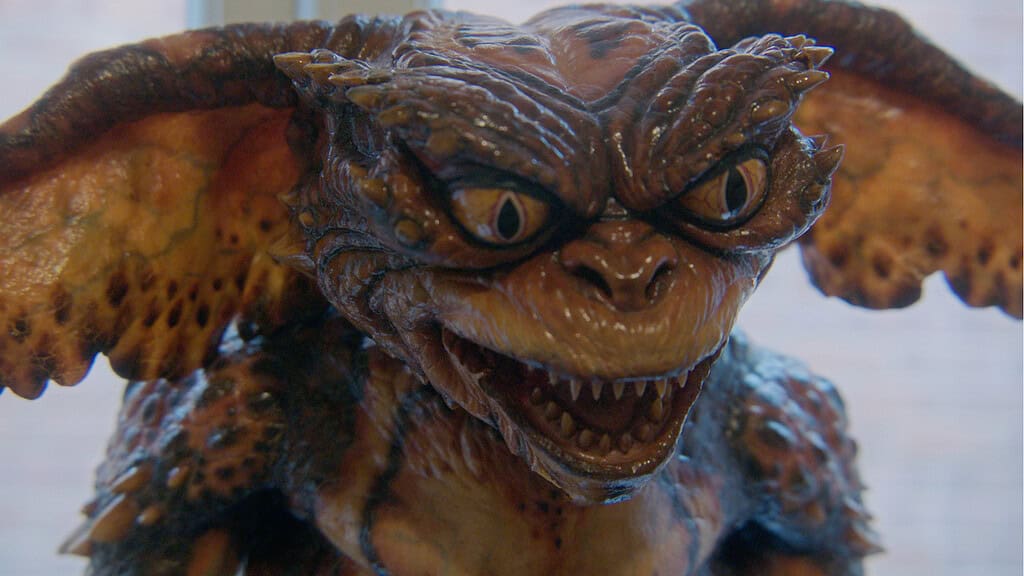 Close-up of a detailed gremlin figurine showing a mischievous expression and textured skin under soft lighting.