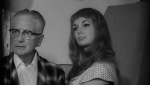‘Common Law Wife’ & ‘Jennie, Wife/Child’ Backwoods Double Feature Blu-Ray Review – All In The Family An older man wearing glasses and a plaid jacket stands beside a younger woman with long hair, wearing a polka dot top, both looking in the same direction.