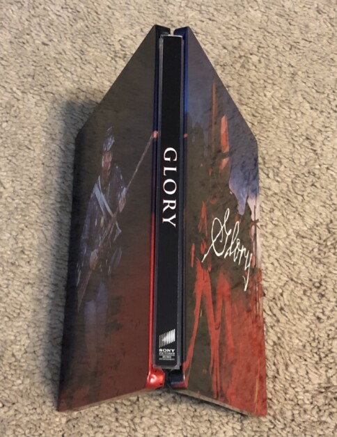 Blu-ray case for the movie "Glory" is open and standing upright on a carpeted floor. The case features artwork of soldiers in Civil War attire.