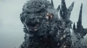 A close-up of Godzilla, a giant, reptilian monster, with glowing eyes and smoke emanating from its rough, rocky skin.