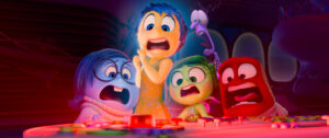 Five animated characters with expressions of shock and alarm, grouped around a control panel with red warning buttons.