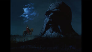 ‘Ruslan And Ludmila’ Blu-Ray Review – Epic Fairy Tale Is Brilliant Unbridled Creativity A person on a horse in a red cape looks at a giant, weathered stone head structure under a cloudy, moonlit night sky.