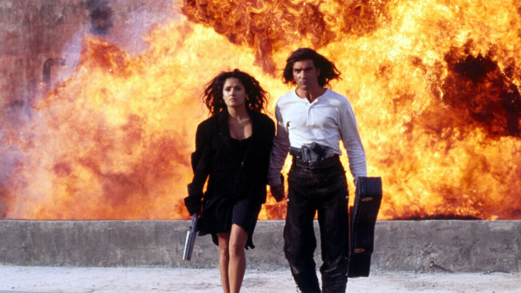 Two individuals, one holding a gun and the other a guitar case, walk away from a large explosion in the background. The scene suggests action or adventure.