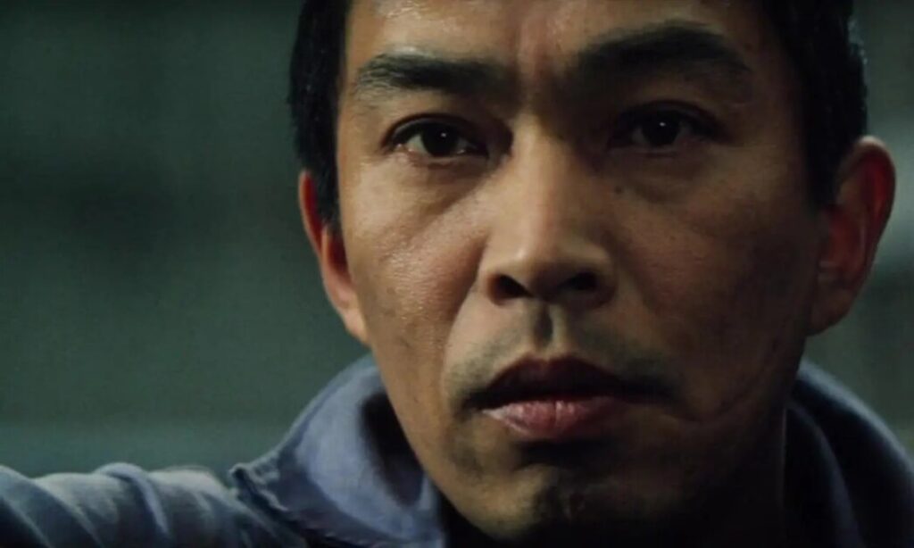 Close-up of a person's face with a serious expression, looking slightly to the side.