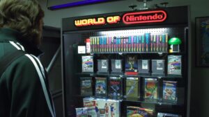 A person looking at a display case titled "World of Nintendo" showcasing various retro Nintendo games and memorabilia.