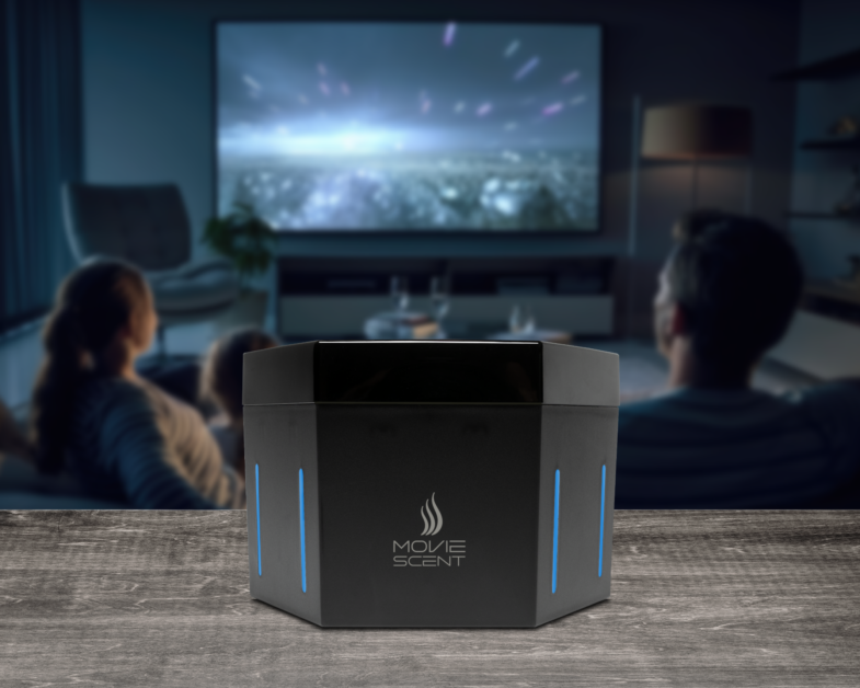 A family watches a movie in a dimly lit room. In the foreground, a device labeled "MOVE SCENT" with blue lights is placed on a table.