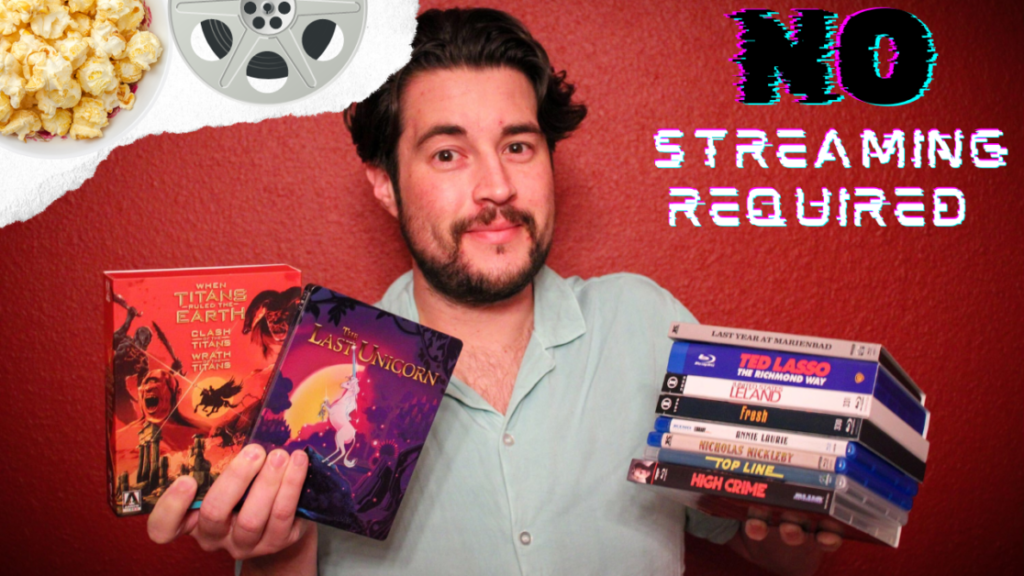 A person holds a selection of DVDs with a "No Streaming Required" sign above. A bowl of popcorn and a film reel are in the top corners. Background is red-orange.