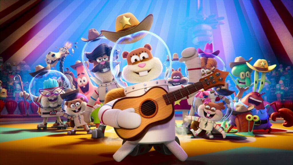 A cartoon squirrel in a spacesuit and cowboy hat plays a guitar in the foreground, surrounded by various animated characters in colorful outfits under a circus-like tent.