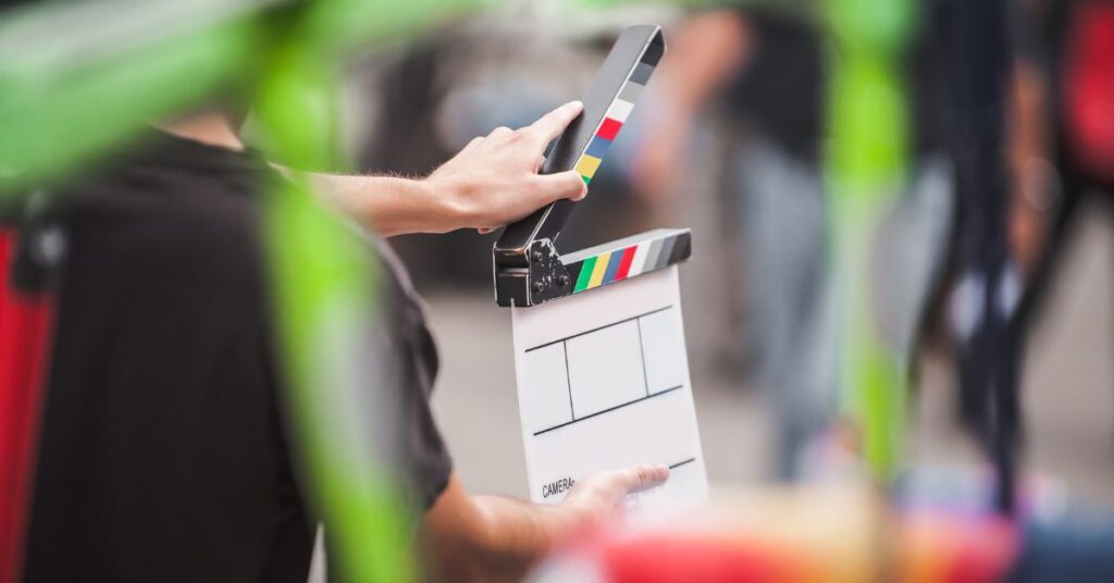 A person holding a clapperboard on a film set, preparing to mark the start of a scene.