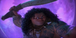 Disney To Release The Blockbuster Animated Sequel ‘Moana 2’ On 4K UHD Blu-Ray This March A character with long curly hair and tribal tattoos is holding a large weapon against a purple background.