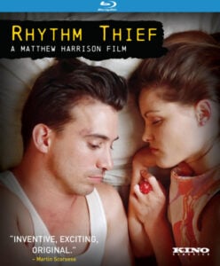 Cover of "Rhythm Thief" Blu-ray showing a close-up of a man lying next to a woman holding a red object.