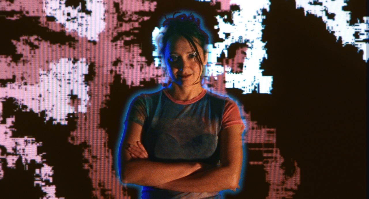 A person stands with arms crossed against a vibrant, abstract digital background.