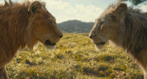 Two male lions face each other on a grassy landscape with hills and a partly cloudy sky in the background.