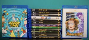 A collection of Blu-ray discs featuring various film and animation titles, including "Looney Tunes" and "Humoresque," displayed against a green background.