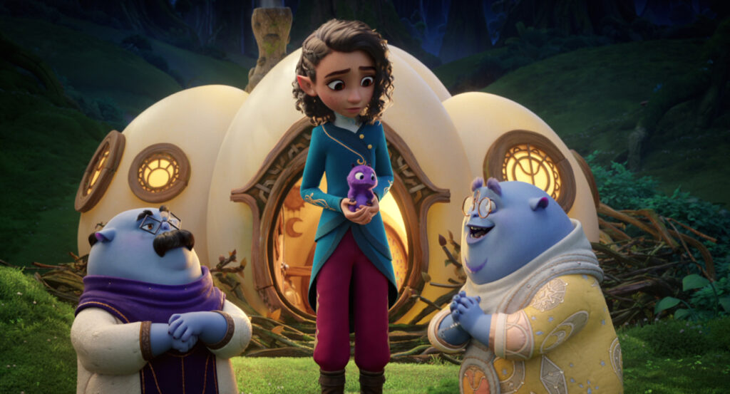 Animated scene with an elf holding a small purple creature, standing between two smiling blue goblins in front of a whimsical house.