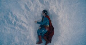 ‘Superman’ Teaser Trailer Breakdown: Look Up! (At Everything You Need To Know) Person in a superhero costume lying on snowy ground, covered in snow.