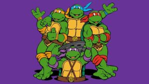 GVN Giveaway: ‘Teenage Mutant Ninja Turtles’ Merch Pack Four animated green turtles with colored masks and belts pose against a purple background.