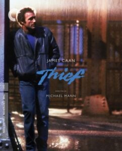 Cover of the film "Thief" featuring a man in a leather jacket standing in a dimly lit, rainy street. Text reads: "James Caan, Thief, Directed by Michael Mann." Criterion Collection label.