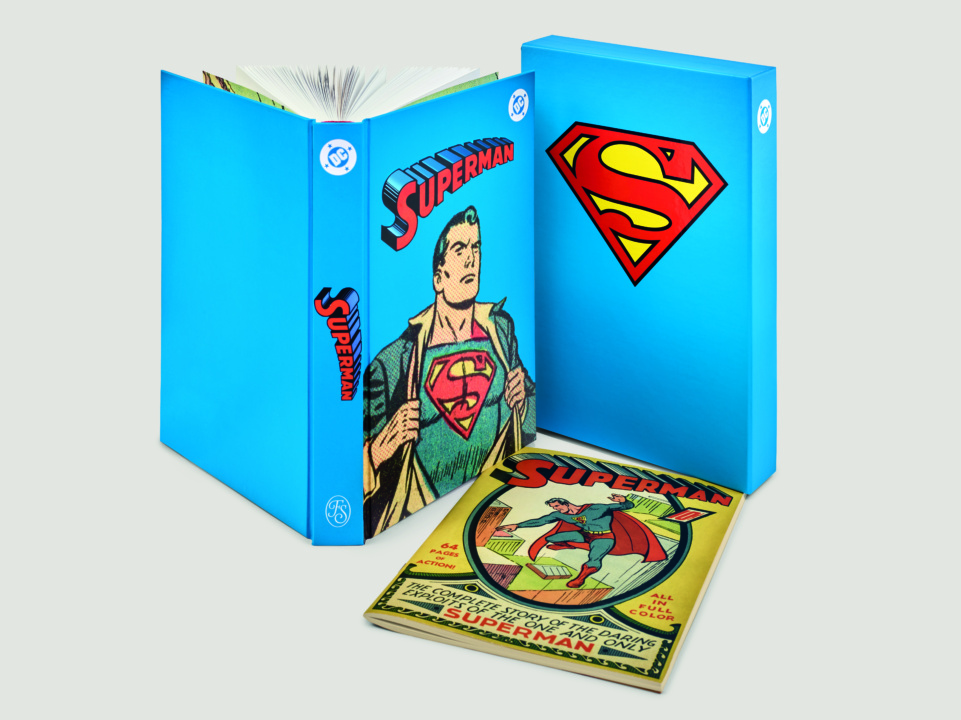 A blue Superman box set with a hardcover book and a vintage comic book featuring Superman on the covers.