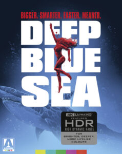 Movie poster for "Deep Blue Sea" featuring a woman swimming above a shark. Text reads "Bigger. Smarter. Faster. Meaner." Includes 4K UHD and HDR mention at the bottom.