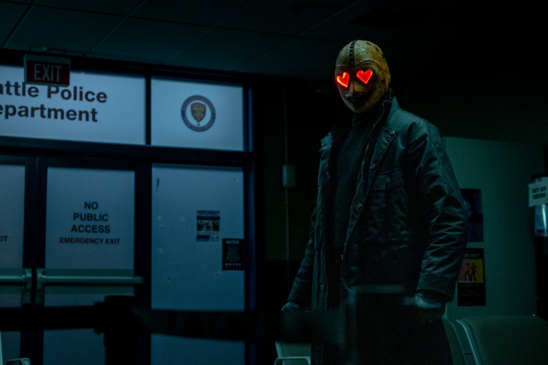 A person wearing a mask with glowing heart-shaped eyes stands in a dimly lit room labeled "Police Department.