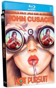 Blu-ray cover of "Hot Pursuit" featuring stylized artwork of a woman looking through binoculars, with a surprised expression, and sipping a drink with a straw.