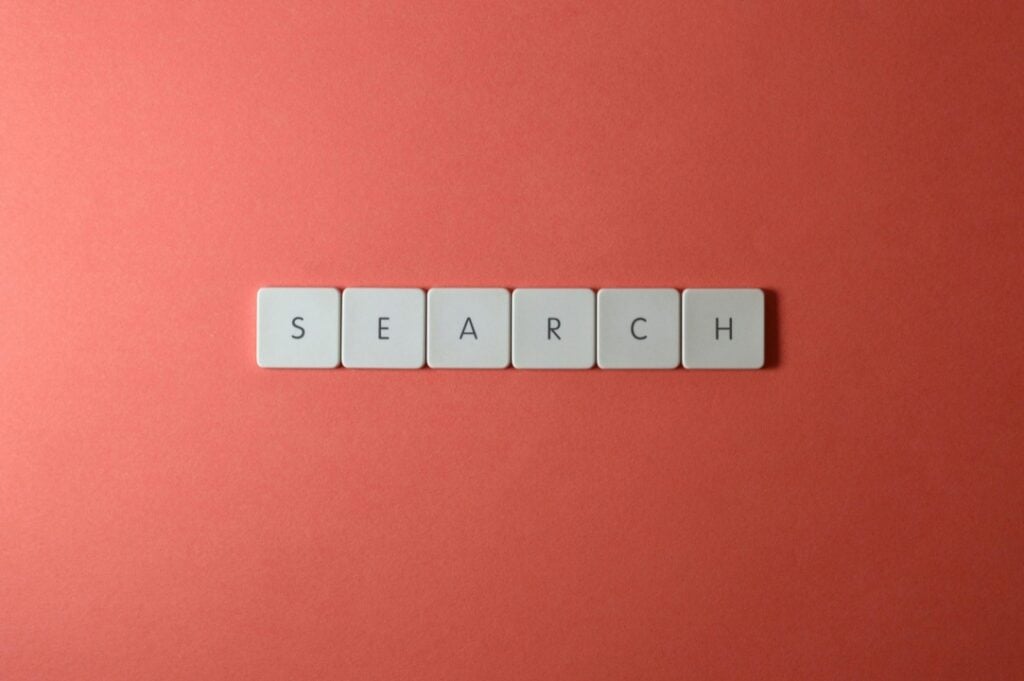 Tiles spelling "SEARCH" on a red background.