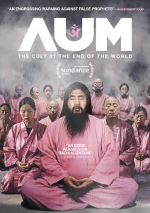 A group of people in pink robes with closed eyes sit behind a bearded man, shown on a poster for "AUM: The Cult at the End of the World," with film festival accolades and review quotes.