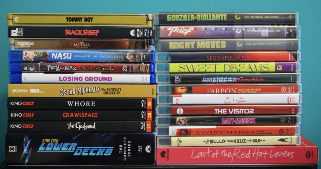 A collection of DVD and Blu-ray cases stacked in two columns against a blue background, featuring various movie titles.