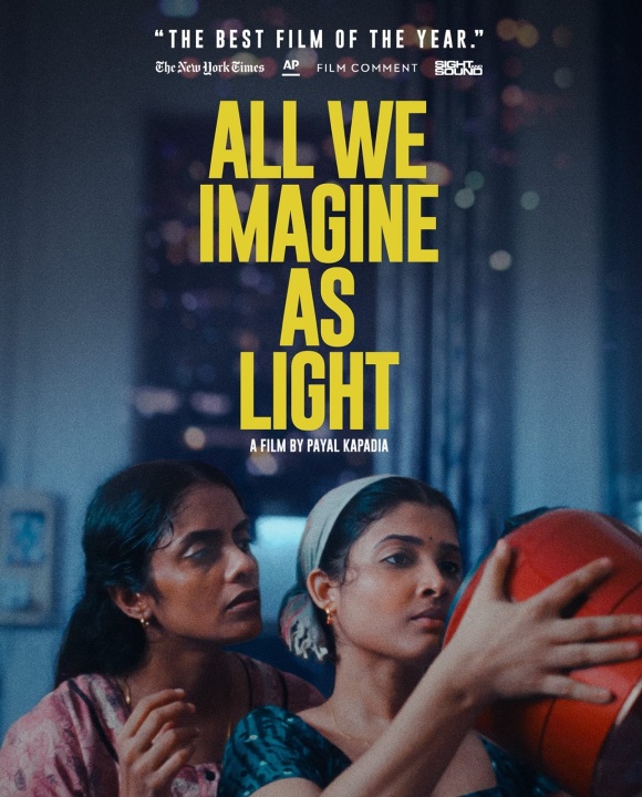 Two women stand closely together indoors, one holding a basketball, with the title "All We Imagine As Light" and film credits displayed above them.