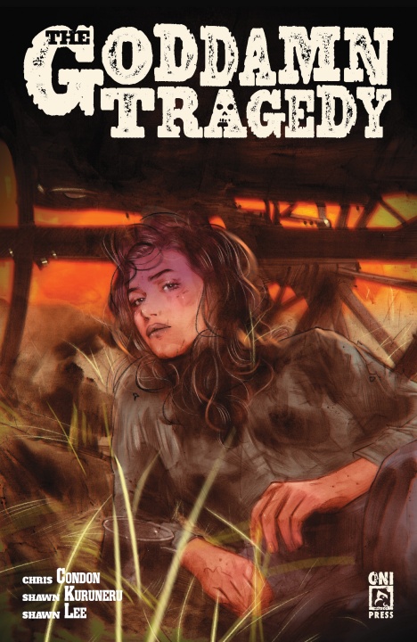 A woman with long hair lies on the ground under debris with an orange sky in the background. The cover text reads "The Goddamn Tragedy" and lists creators and publisher logos.