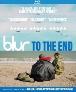 Blu-ray cover for "Blur: To The End" featuring three people sitting on a pebbled beach, with the sea and blue sky in the background and reviews at the top.
