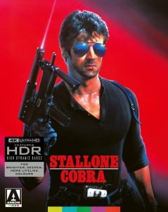 A man in sunglasses and black shirt holds a submachine gun against a red background. Text reads: “Stallone Cobra.” 4K Ultra HD and Arrow Video logos are visible.