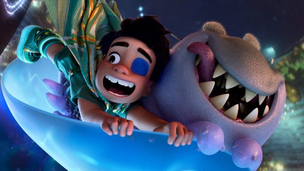 An animated boy with an eye patch and a smiling purple creature slide together in a large blue bowl, both appearing excited.