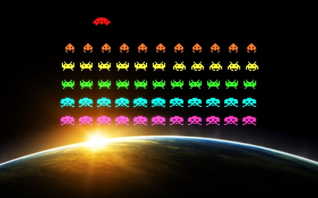 Pixelated Space Invaders characters in bright colors hover over Earth as the sun rises in the background, blending retro video game imagery with a space scene.