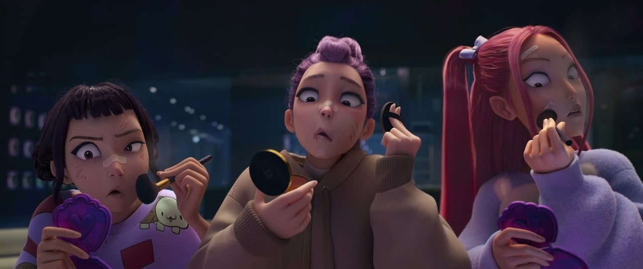 Three animated girls with surprised expressions apply makeup while looking into compact mirrors.