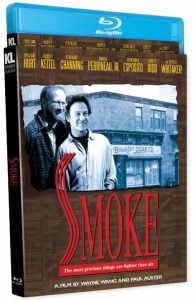 Blu-ray cover of the film "Smoke" featuring two men standing in front of a cigar shop, with the movie title in large red letters and cast names listed above.
