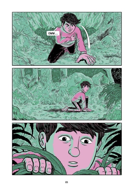 A young person with short dark hair crawls through thick green foliage, wincing in pain, then looks ahead with a surprised expression.