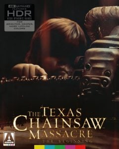 A person stands behind a large chainsaw in dim lighting on the cover of "The Texas Chainsaw Massacre: The Beginning" 4K Ultra HD edition.