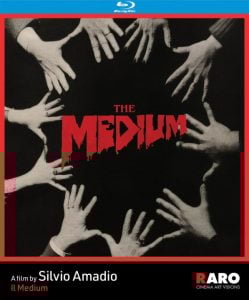 Black-and-white photo of several hands reaching toward the center around the red text "THE MEDIUM" on a Blu-ray film cover.