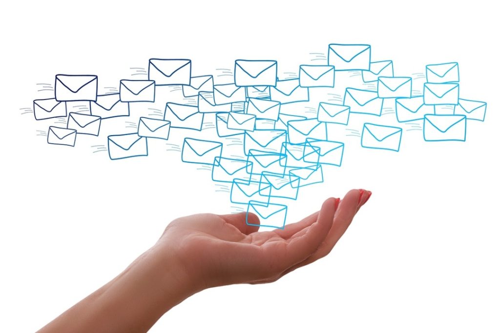 An open hand with illustrated envelopes floating above it, representing the concept of sending or receiving emails.