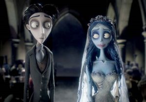 Two animated characters, a pale man in a suit and a blue-skinned woman in a wedding dress, stand side by side in a dimly lit, gothic setting.