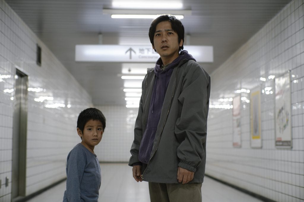 A man and boy standing in a hallway.
