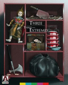 A shelf displays a doll, a meat cleaver, a stack of tiffin containers, a sleeping woman in a box, an axe, and a black duffel bag. Text reads "Three... Extremes." Arrow Video logo is present.