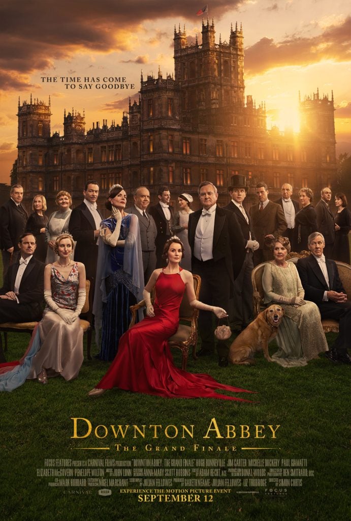 A formal group of characters from Downton Abbey pose in front of a large historic estate at sunset, promoting the series' grand finale.