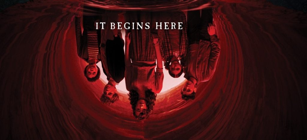 Six people stand in a line, shown upside down with a red background and the text "IT BEGINS HERE" above them.