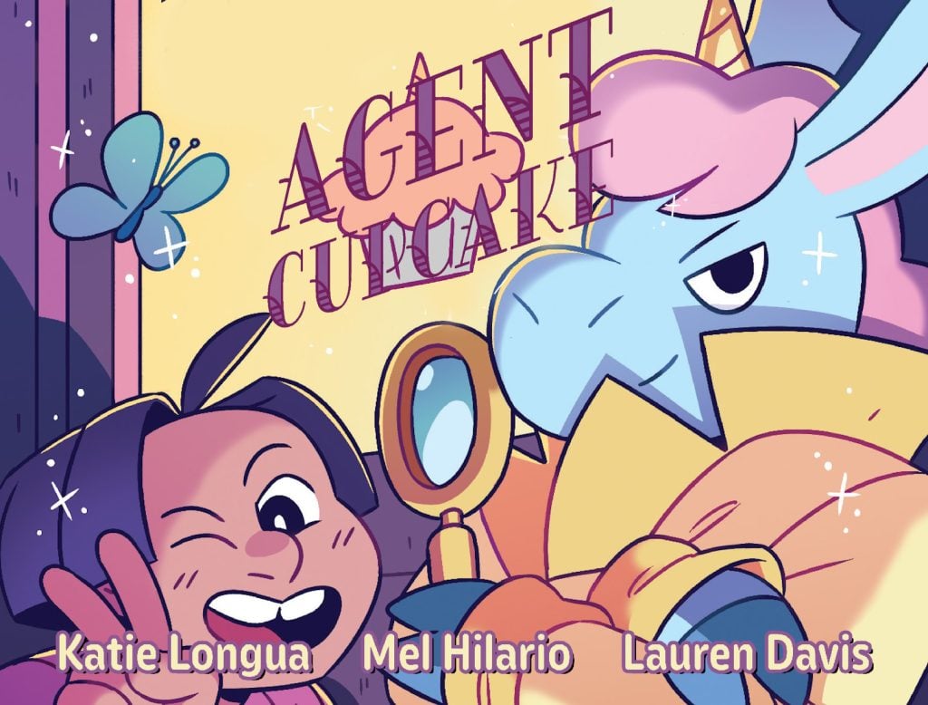 A cartoon girl flashes a peace sign next to a serious unicorn in armor; text reads "Agent Cupcake" and credits Katie Longua, Mel Hilario, and Lauren Davis.
