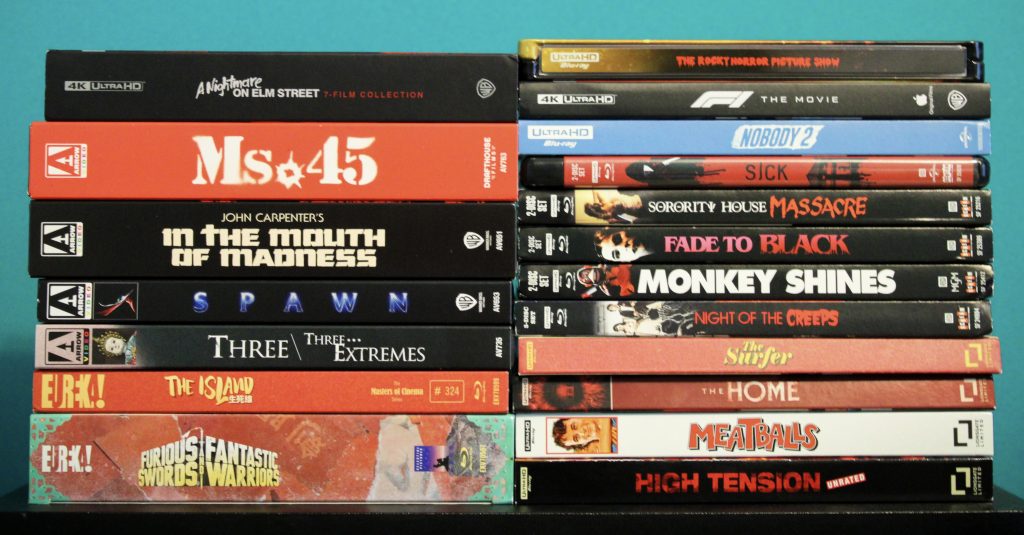 A stack of various Blu-ray and DVD movie cases arranged in two columns against a turquoise background.