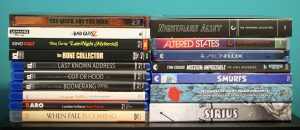 A collection of DVDs and Blu-rays arranged in two vertical stacks against a blue background, with various movie and TV series titles visible on the spines.